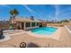 Serene backyard retreat with sparkling blue pool, desert landscaping, and covered patio at 7940 W Willow Ave, Peoria, AZ 85381