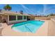Backyard view showcasing a sparkling blue pool, screened-in patio, and ample outdoor space at 7940 W Willow Ave, Peoria, AZ 85381