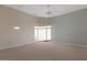 An airy bedroom features neutral paint, ceiling fan, and natural light from a large window at 8540 E Mcdowell Rd # 119, Mesa, AZ 85207
