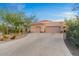 Three-car garage and driveway of home with desert landscaping at 8540 E Mcdowell Rd # 119, Mesa, AZ 85207