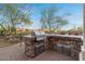 Outdoor kitchen on a brick patio features a built-in grill and counter space, ideal for barbecues at 8540 E Mcdowell Rd # 119, Mesa, AZ 85207