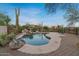 Beautiful swimming pool with rock waterfall feature and mature desert landscaping, creating an oasis-like setting at 8540 E Mcdowell Rd # 119, Mesa, AZ 85207
