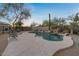 Backyard pool area with desert landscaping, natural rock waterfall, and wrought iron fence at 8540 E Mcdowell Rd # 119, Mesa, AZ 85207