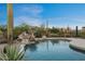 Private in-ground pool area with boulder waterfall feature, desert landscaping, and privacy fence at 8540 E Mcdowell Rd # 119, Mesa, AZ 85207