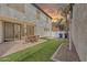 Charming backyard with brick patio, artificial grass, seating, and exterior house view at 10428 E Nopal Ave, Mesa, AZ 85209