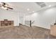 Bright bonus room with neutral carpet, ceiling fan, and staircase access at 10428 E Nopal Ave, Mesa, AZ 85209