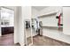 Walk-in closet with ample shelving and hanging space, adjoining a bathroom, and carpeted floor at 10428 E Nopal Ave, Mesa, AZ 85209