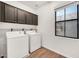 Bright laundry room with a window, upper cabinets, and modern appliances at 10428 E Nopal Ave, Mesa, AZ 85209