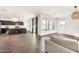 Spacious living room features a seamless open floor plan with dark wood-look tile and modern light fixtures at 10428 E Nopal Ave, Mesa, AZ 85209