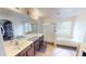 A bright bathroom featuring tile floors, a dark wood vanity, and a separate shower and tub at 10441 W Windsor Ave, Avondale, AZ 85392
