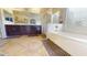 This bright bathroom has a stand-alone tub, dark wood vanity and large mirror at 10441 W Windsor Ave, Avondale, AZ 85392