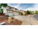 Two-story tan home featuring desert landscaping, three car garage, and charming street appeal at 10441 W Windsor Ave, Avondale, AZ 85392