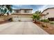 Tan two-story home featuring a spacious three-car garage and desert landscaping at 10441 W Windsor Ave, Avondale, AZ 85392