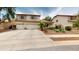 Two-story tan home with a spacious driveway, desert landscaping, and well-maintained curb appeal at 10441 W Windsor Ave, Avondale, AZ 85392