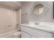 Bathroom featuring a shower-tub combo, a vanity with storage, and an attractive circular mirror at 1173 E Cochise Dr, Phoenix, AZ 85020