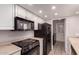 Well-lit kitchen featuring white cabinetry and modern black appliances, ready for your culinary creations at 1173 E Cochise Dr, Phoenix, AZ 85020