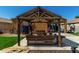 Enjoy the shade in this backyard's wooden pergola with light fixtures and rustic table and chairs at 1223 E Palo Verde Dr, Casa Grande, AZ 85122