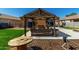 Enjoy the shade in this backyard's wooden pergola with light fixtures and rustic table and chairs at 1223 E Palo Verde Dr, Casa Grande, AZ 85122