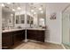 This bathroom boasts dual sinks with dark wood cabinets and large mirrors under modern lighting at 1223 E Palo Verde Dr, Casa Grande, AZ 85122