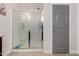 Bathroom features a shower with sliding doors and a gray paneled door at 1223 E Palo Verde Dr, Casa Grande, AZ 85122