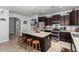 Well-equipped kitchen with island, stainless steel appliances, dark wood cabinets, and plenty of counter space at 1223 E Palo Verde Dr, Casa Grande, AZ 85122