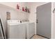 Bright laundry room featuring a white washer and dryer and shelving at 1223 E Palo Verde Dr, Casa Grande, AZ 85122