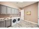 Well-equipped laundry room with modern washer and dryer, sink, and cabinet storage space at 12448 N 129Th Pl, Scottsdale, AZ 85259