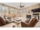 Inviting living room with stone fireplace, plantation shutters, and comfortable leather furniture at 12448 N 129Th Pl, Scottsdale, AZ 85259