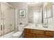 Bright bathroom featuring a shower-tub combination, a wood vanity, and a large mirror at 125 N 22Nd Pl # 53, Mesa, AZ 85213
