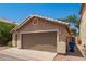 Rear exterior of the home showcasing a two-car garage and low maintenance yard at 125 N 22Nd Pl # 53, Mesa, AZ 85213