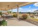Spacious covered back patio overlooking a large yard with mature landscaping, trampoline, and outdoor seating at 1409 E Dove Pl, Casa Grande, AZ 85122