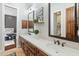 Modern bathroom featuring double sinks, quartz countertops, dark wood cabinetry, and bedroom view at 1409 E Dove Pl, Casa Grande, AZ 85122