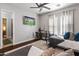 Comfortable bedroom with hardwood floors, a ceiling fan, a television, and a stylish desk at 1409 E Dove Pl, Casa Grande, AZ 85122