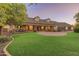 Lovely front yard with a well-manicured lawn, mature trees, and charming front porch with seating at 1409 E Dove Pl, Casa Grande, AZ 85122