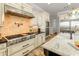 The kitchen features stainless steel appliances, travertine flooring, a kitchen island with a sink, and a tile backsplash at 1409 E Dove Pl, Casa Grande, AZ 85122