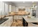 Chef's kitchen featuring a large island with seating, stainless steel appliances, travertine tile flooring, and custom cabinetry at 1409 E Dove Pl, Casa Grande, AZ 85122