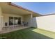 Outdoor patio with artificial grass, a table, and seating with sliding glass door access to the home at 17205 N 107Th Ave, Sun City, AZ 85373