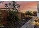 This backyard area has a small walkway with trees along the side of a block fence at 1725 E Everglade Ln, Gilbert, AZ 85298