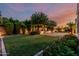 Beautiful backyard featuring vibrant flower beds, a lush lawn, mature landscaping, and a tranquil water feature at 1725 E Everglade Ln, Gilbert, AZ 85298