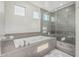 This luxurious bathroom features a tub and a large glass shower with tiled walls at 1725 E Everglade Ln, Gilbert, AZ 85298