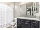 Bathroom features a dark vanity, stylish backsplash, framed mirror, and a shower/tub combo with a modern curtain at 1725 E Everglade Ln, Gilbert, AZ 85298