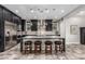 The kitchen has black cabinets, pendant lighting, stainless steel appliances, an island with seating, and tile floors at 1725 E Everglade Ln, Gilbert, AZ 85298
