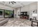 View of the living room with tile floors, a ceiling fan, a leather couch, and a glass sliding door at 1725 E Everglade Ln, Gilbert, AZ 85298
