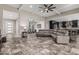 Open-concept living room with tile floors, a large leather couch, access to the kitchen, and coffered ceilings at 1725 E Everglade Ln, Gilbert, AZ 85298