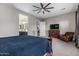 Comfortable main bedroom boasts a ceiling fan, dresser, and an accompanying sitting chair at 1725 E Everglade Ln, Gilbert, AZ 85298