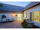 Cozy back patio with a water fountain, chairs, and access to an open dining room, creating a serene outdoor retreat at 18 W Kaler Dr, Phoenix, AZ 85021