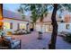 Charming courtyard with brick pavers, mature trees, and seating area, offering a private outdoor space at 18 W Kaler Dr, Phoenix, AZ 85021