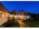 Elegant gated entrance leading to a charming home with a brick pathway and manicured landscaping at dusk at 18 W Kaler Dr, Phoenix, AZ 85021
