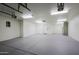 Spacious three car garage with recessed lighting, neutral walls, and painted concrete floors at 18 W Kaler Dr, Phoenix, AZ 85021