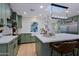 Stylish green kitchen featuring a large island, modern appliances, and a skylight above at 18 W Kaler Dr, Phoenix, AZ 85021